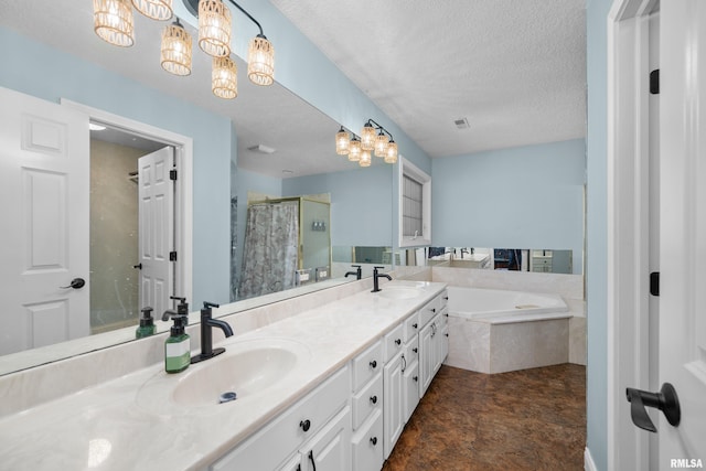 full bathroom featuring a textured ceiling, a bath, a stall shower, and a sink