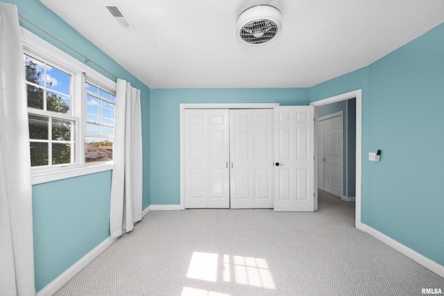 unfurnished bedroom featuring visible vents, baseboards, carpet, and a closet