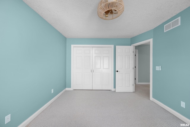 unfurnished bedroom with a closet, visible vents, baseboards, and carpet