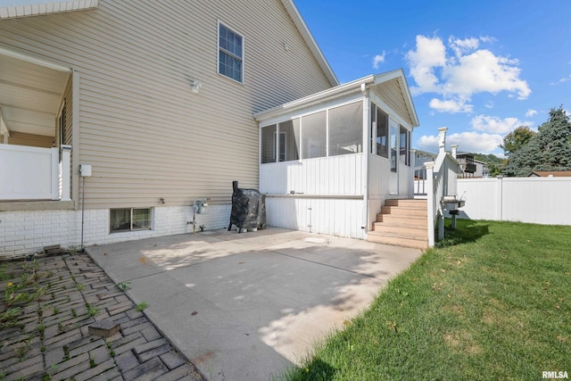 rear view of property with a patio, a yard, fence, and a sunroom