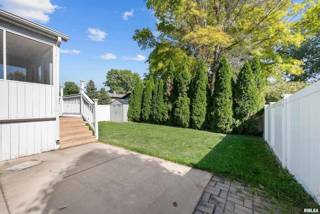 view of yard featuring a fenced backyard, a sunroom, an outdoor structure, a storage unit, and a patio area