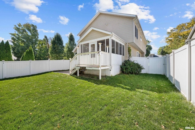 back of property featuring a gate, a fenced backyard, a yard, and a sunroom