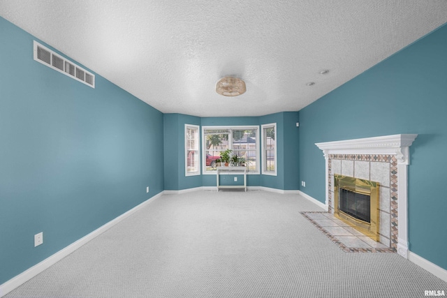 unfurnished living room featuring visible vents, a tile fireplace, carpet, and baseboards