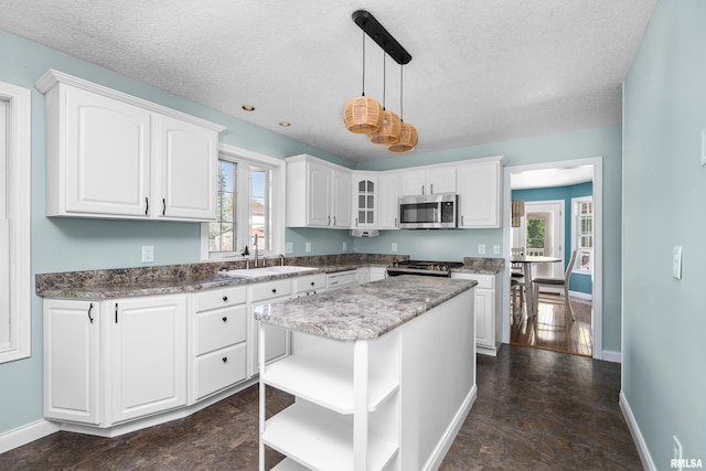 kitchen featuring a sink, white cabinetry, stainless steel appliances, and open shelves