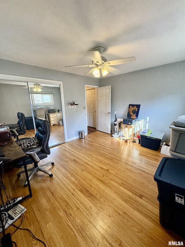 office with baseboards, a textured ceiling, wood finished floors, and a ceiling fan