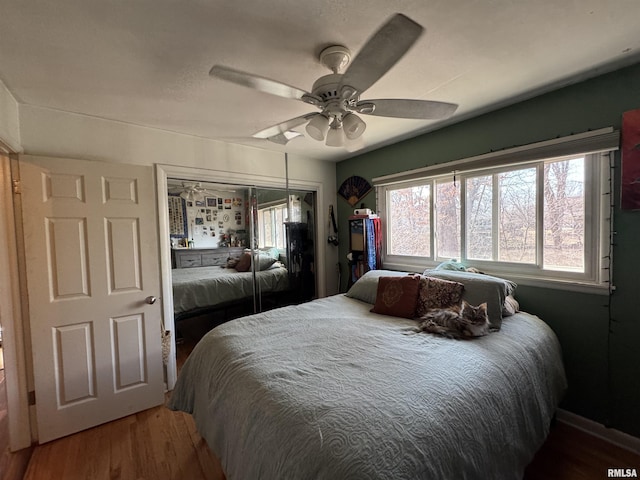 bedroom featuring a closet, wood finished floors, and a ceiling fan