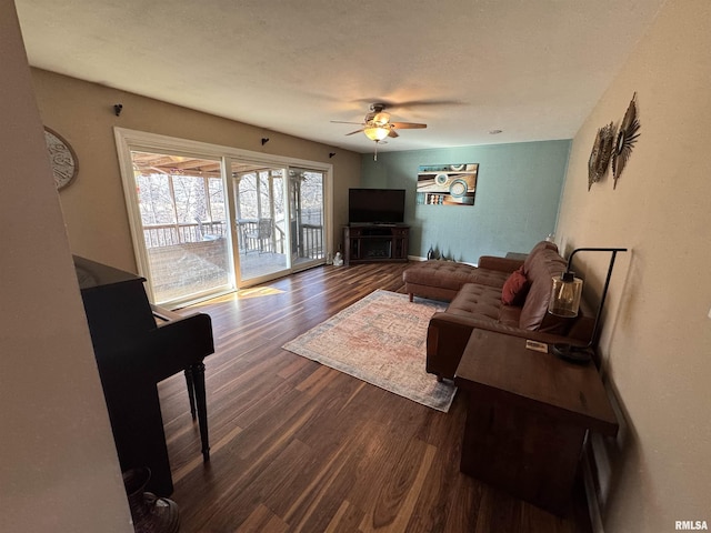 living area featuring dark wood-style floors, a textured ceiling, and a ceiling fan