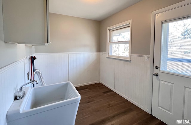 laundry room with a wainscoted wall, dark wood finished floors, laundry area, a sink, and washer hookup