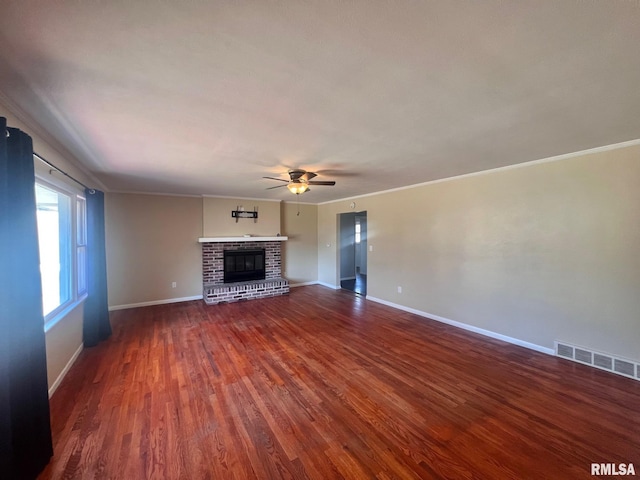 unfurnished living room featuring a brick fireplace, wood finished floors, visible vents, and baseboards