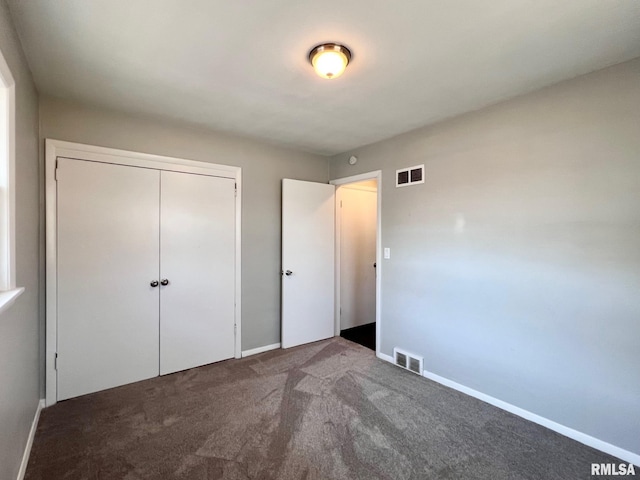 unfurnished bedroom featuring visible vents, baseboards, carpet, and a closet