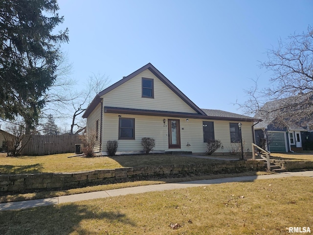 view of front facade featuring an outbuilding, a front lawn, and fence