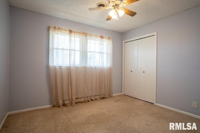 unfurnished bedroom with a closet, baseboards, a textured ceiling, and carpet flooring