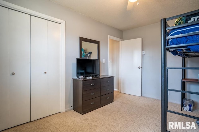 carpeted bedroom with a ceiling fan and a closet