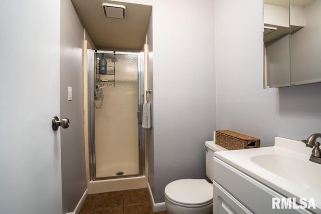 bathroom with tile patterned flooring, a shower stall, baseboards, toilet, and vanity