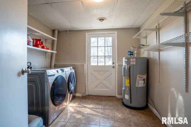 laundry area with visible vents, washing machine and clothes dryer, water heater, and laundry area