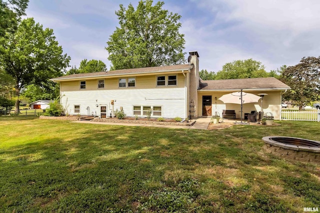 back of house featuring a patio, a yard, fence, and a chimney