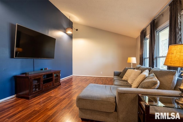 living room featuring baseboards, lofted ceiling, and wood finished floors