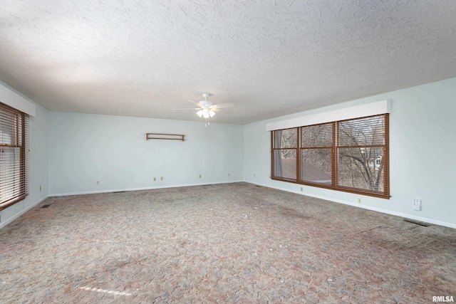 spare room featuring visible vents, plenty of natural light, baseboards, and ceiling fan