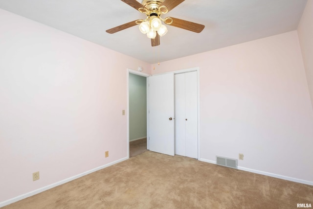 unfurnished bedroom featuring baseboards, visible vents, a closet, and light carpet