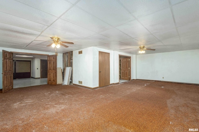 unfurnished living room featuring a drop ceiling, a ceiling fan, baseboards, and carpet floors