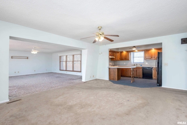 unfurnished living room with visible vents, a ceiling fan, a textured ceiling, baseboards, and light colored carpet