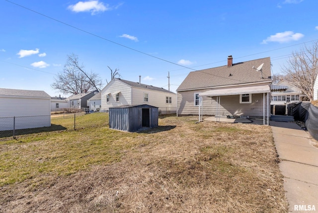 back of house with a fenced backyard, a lawn, a storage unit, and an outdoor structure