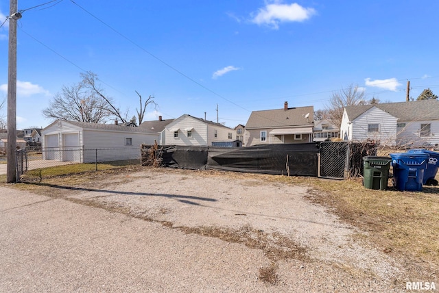 view of yard featuring a gate, fence, a residential view, and dirt driveway