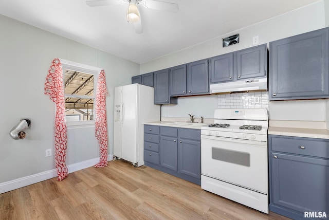 kitchen with under cabinet range hood, white appliances, ceiling fan, and light countertops