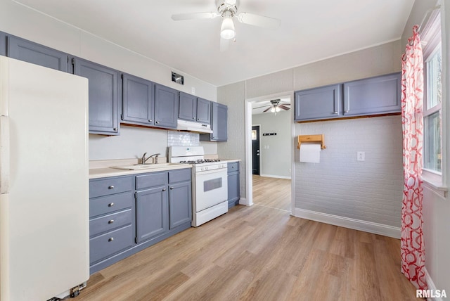 kitchen with white appliances, a ceiling fan, light countertops, light wood-style floors, and under cabinet range hood