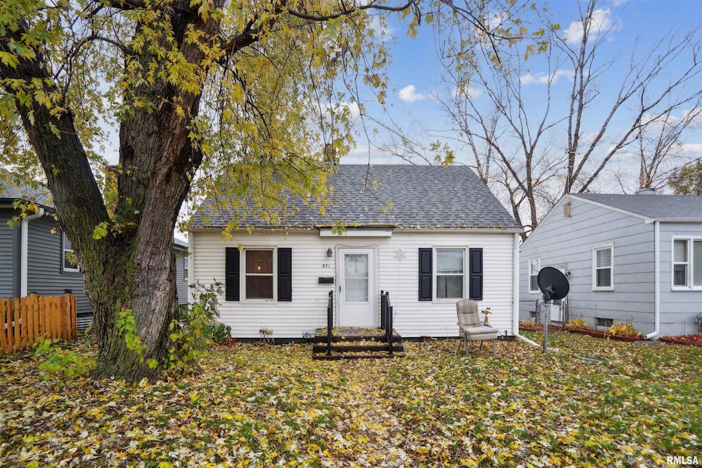 bungalow-style house featuring fence, roof with shingles, and entry steps