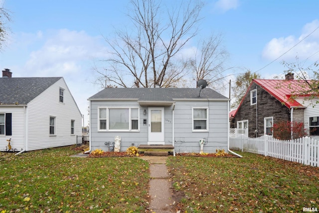 bungalow-style home featuring a front yard and fence