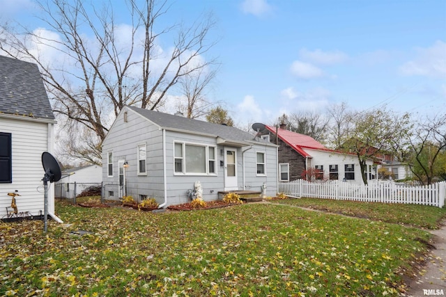 bungalow-style home featuring a front lawn and fence