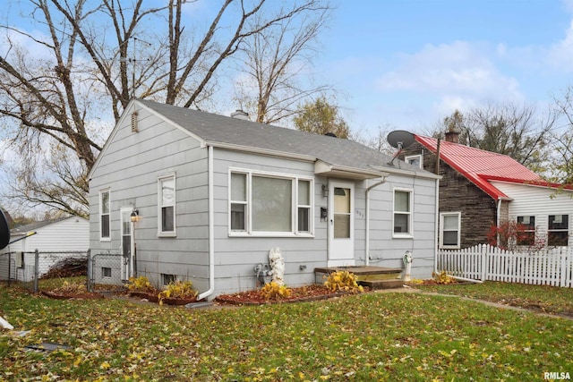 view of front of house featuring a front yard, fence, and a chimney