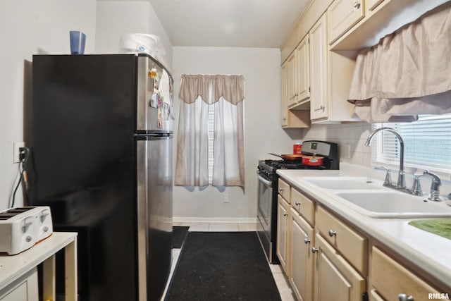 kitchen featuring light tile patterned floors, a sink, stainless steel appliances, light countertops, and backsplash