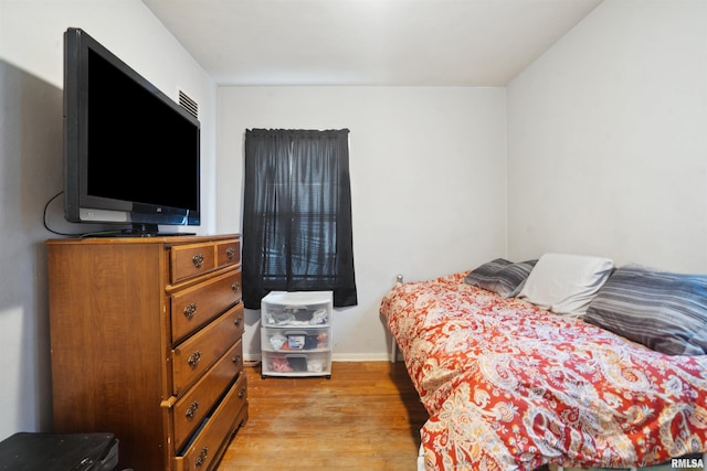 bedroom with light wood-style flooring and baseboards