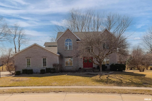 traditional-style home with brick siding and a front lawn