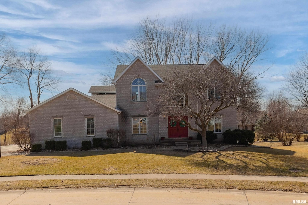 view of front of property featuring a front yard and brick siding