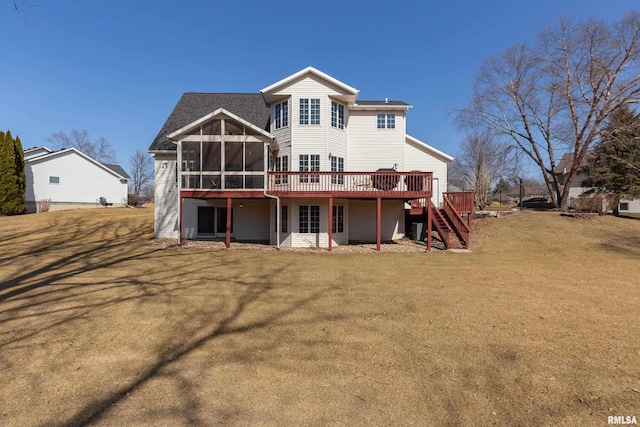 rear view of property with stairway, a lawn, a deck, and a sunroom