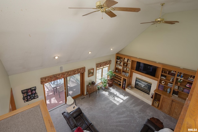 living area with vaulted ceiling, carpet flooring, a fireplace, and ceiling fan