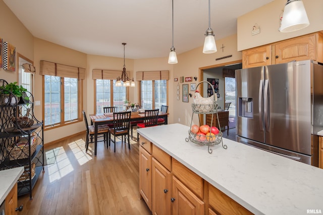 kitchen featuring baseboards, light wood-style floors, stainless steel refrigerator with ice dispenser, decorative light fixtures, and a chandelier