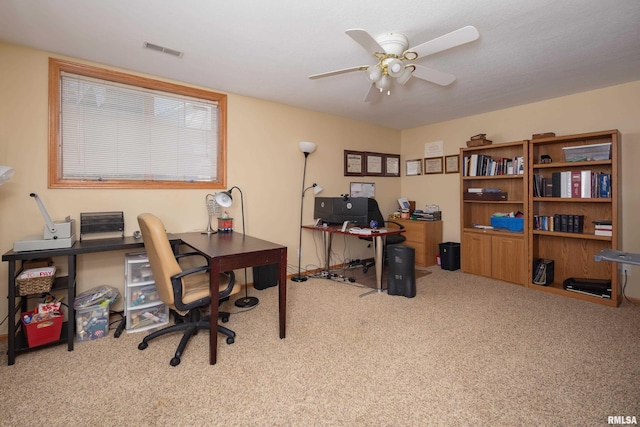 carpeted home office featuring a ceiling fan and visible vents