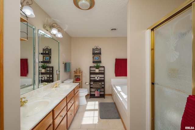 full bathroom featuring a bath, toilet, a textured ceiling, and a sink