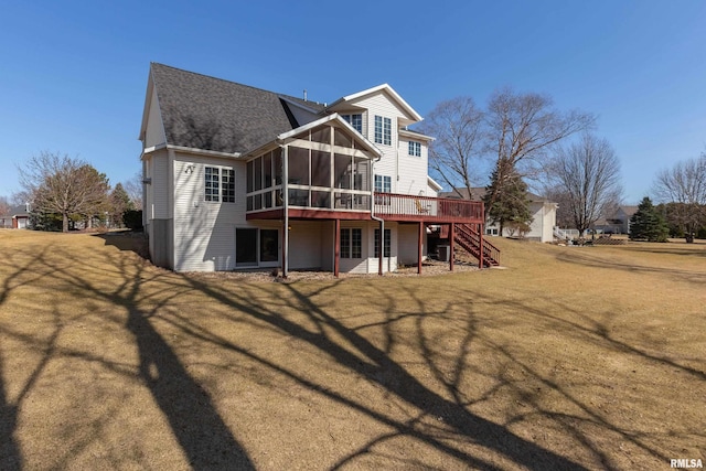 rear view of property featuring stairway, a lawn, a deck, and a sunroom