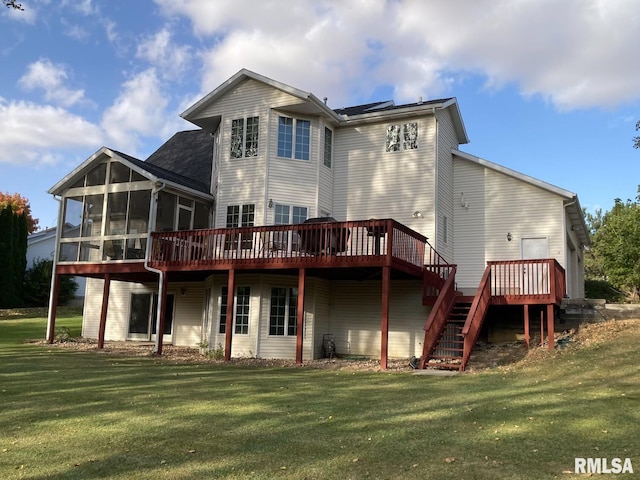 rear view of house with a lawn, stairs, a deck, and a sunroom