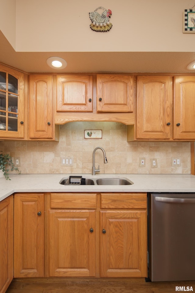 kitchen featuring a sink, tasteful backsplash, dishwasher, and light countertops