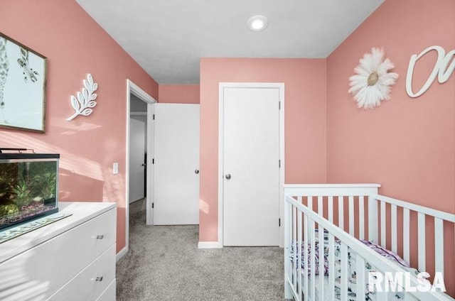 bedroom featuring baseboards, carpet floors, and a crib