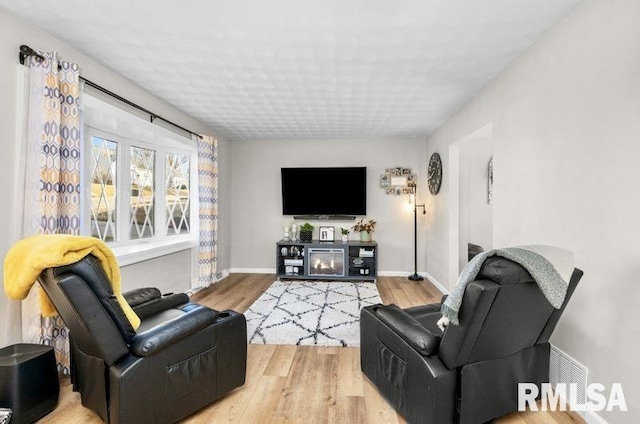 living area with baseboards and wood finished floors