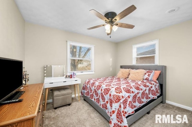 bedroom featuring light colored carpet, baseboards, and ceiling fan