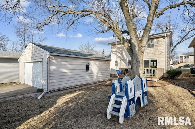 back of house featuring an outbuilding, concrete driveway, and a garage