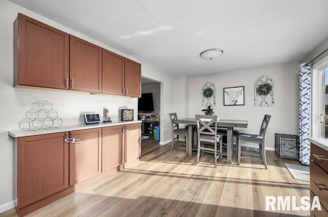 dining room featuring light wood finished floors and baseboards